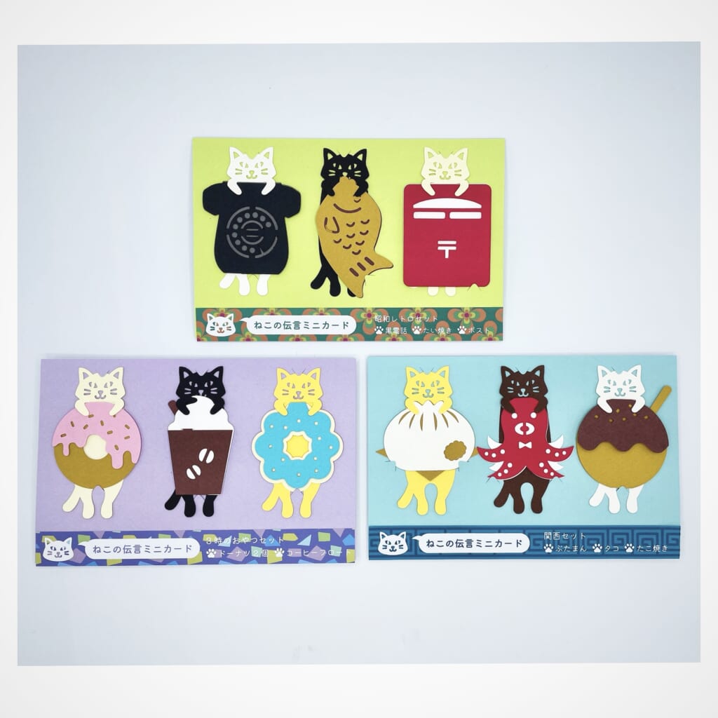 「ねこの伝言ミニカードセット」かわいい猫たちが美味しいたべものを抱えたシリーズを３種類ご用意します。
