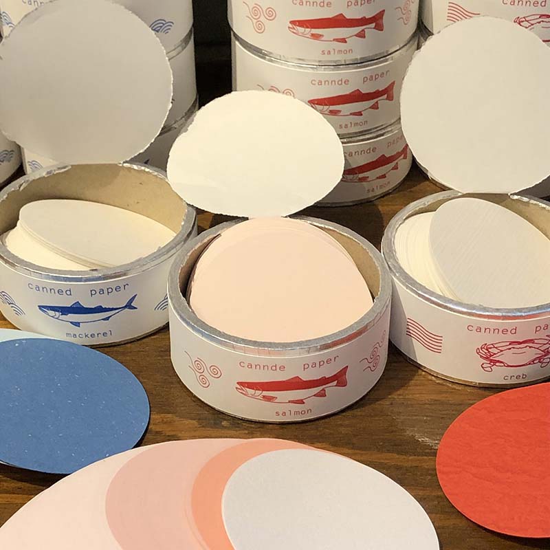 「紙缶」紙で出来た紙の缶詰めです。中には缶ラベルのイメ－ジ色の丸いメモ紙がいっぱいです。開封するのが楽しいメモ紙です。
