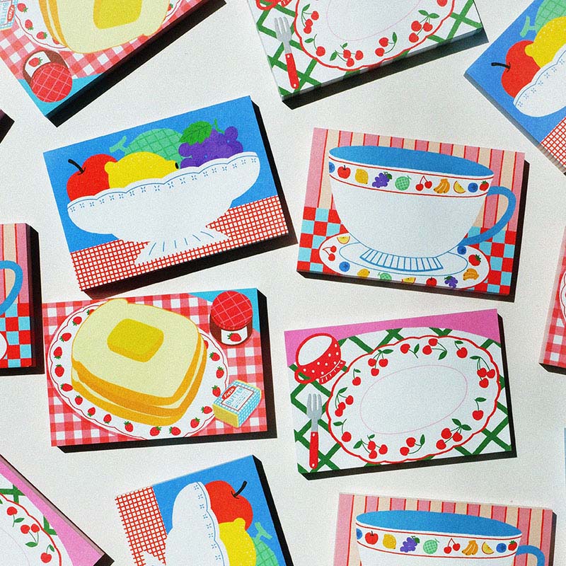 「Fruit Tableware Memo Pad」 色とりどりのかわいい果物とよく似合うテーブルの上のお皿を描いたメモ用紙です。