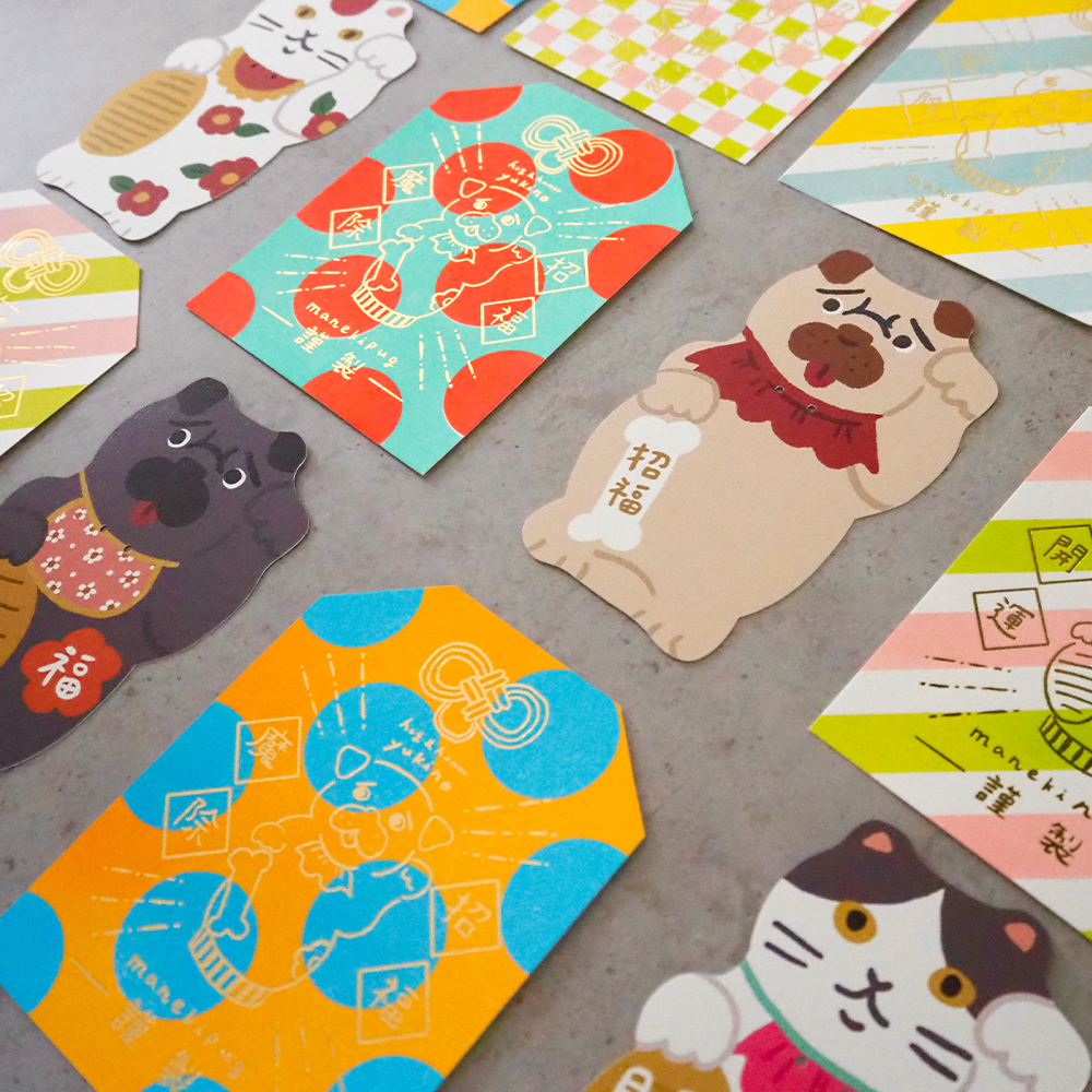 「招きパグ & 招き猫カード」招きシリーズのダイカット鈴つきメッセージカードと箔押しのお守りカード。ダイカットカードは税込450円、箔押しカードは税込330円。