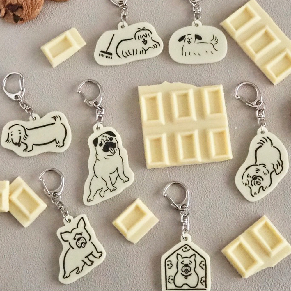 「ホワイトチョコアクキー」チョコみたいな色味が美味しそうなキーホルダー。さまざまな犬のデザインが可愛いアイテムです。税込880円。