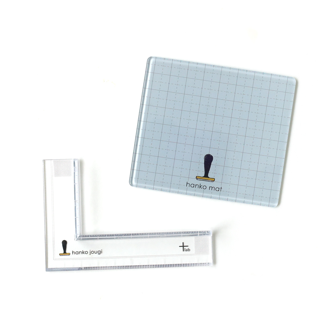 ハンコをよりキレイに押したい時に便利な道具2種類が新しく仲間入り。携帯にも便利な手のひらサイズのハンコマットと、ハンコを真っ直ぐ押すガイドとなる定規です。